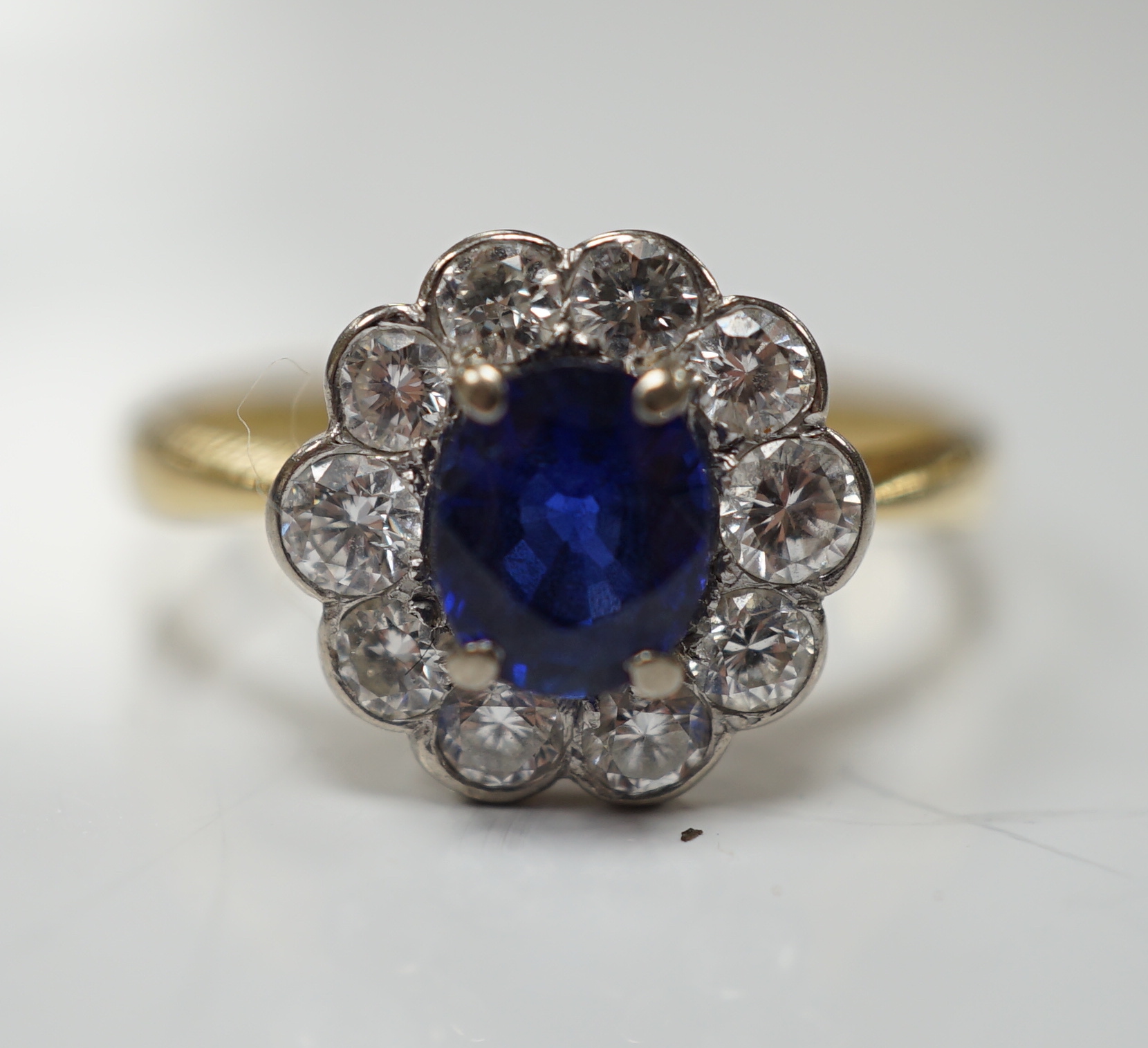 A modern 18ct gold, sapphire and diamond set circular cluster ring, size P/Q, gross weight 3.4 grams.
